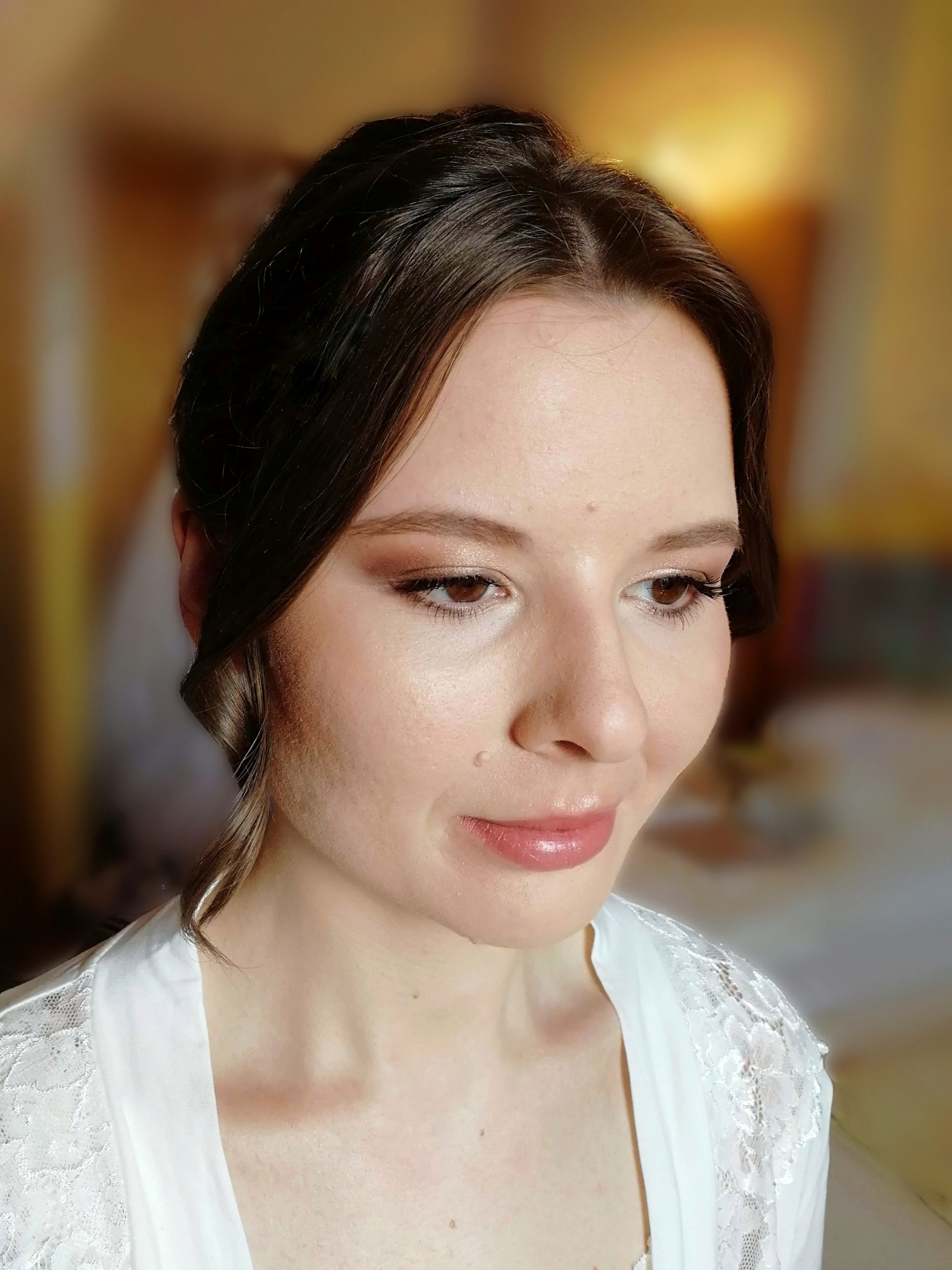 Elegante Braut mit klassischem peachfarbenen Make-Up und hochgesteckten Haaren